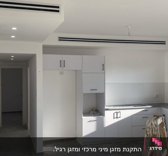 פתחי מיזוג אוויר בתקרה לבנה בחדר ריק